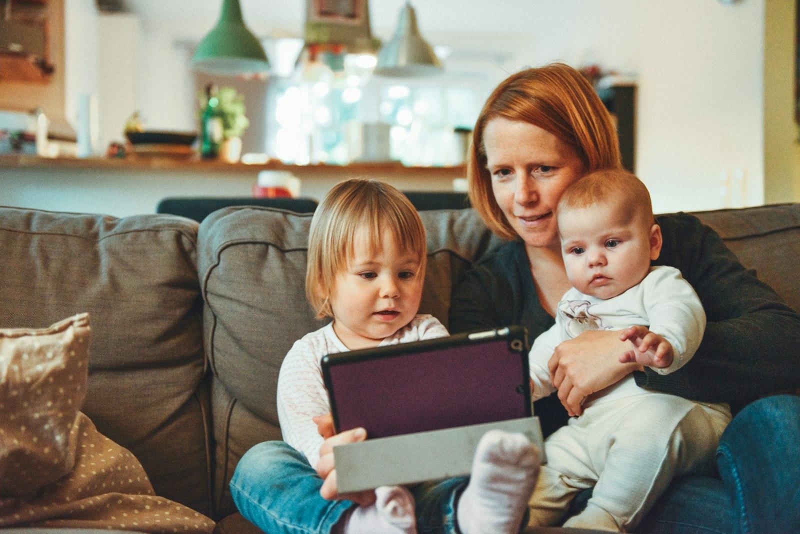Mutter mit zwei kleinen Kindern auf dem Sofa